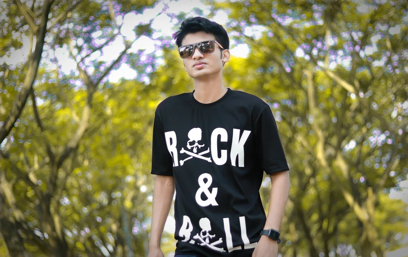 man with sunglasses on, in a black shirt and skull print