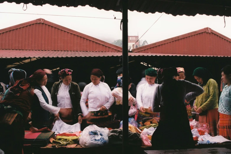 a group of people standing around some food