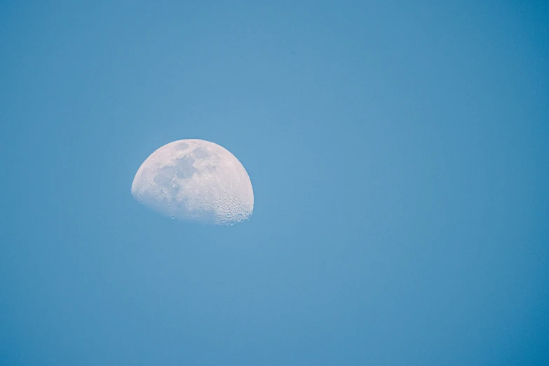 the moon is on a clear blue sky