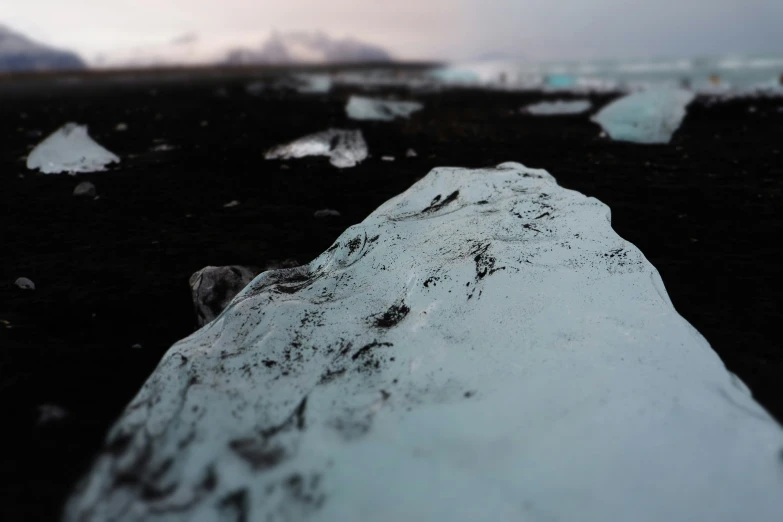 large rock covered with white stuff in a black field