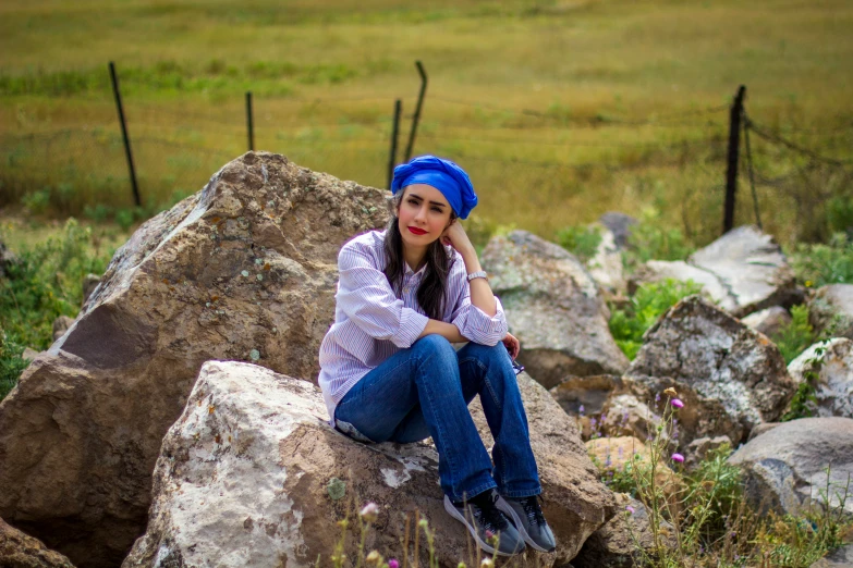 the woman is posing for her picture on the rock