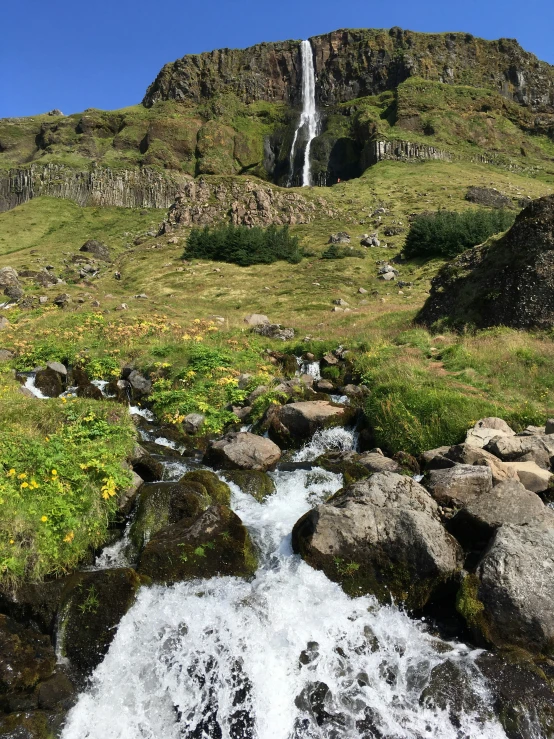 a waterfall running over rocks into the water