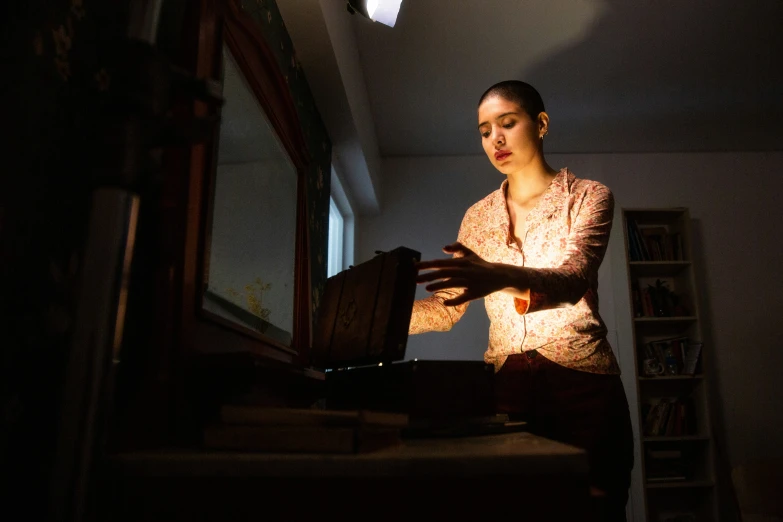 a woman standing near a mirror in the dark