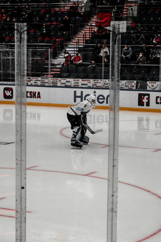 a hockey goaltender standing in front of the goal during the game