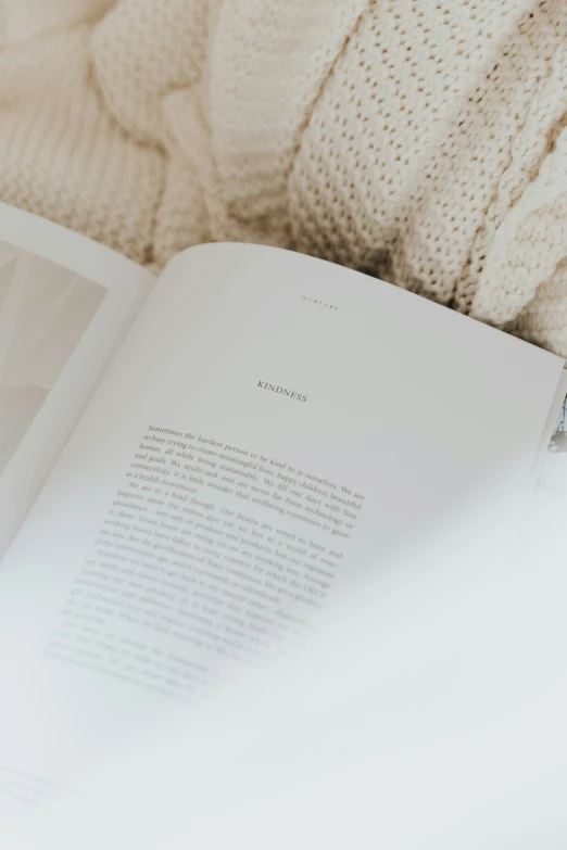 a book laying on top of a white bed