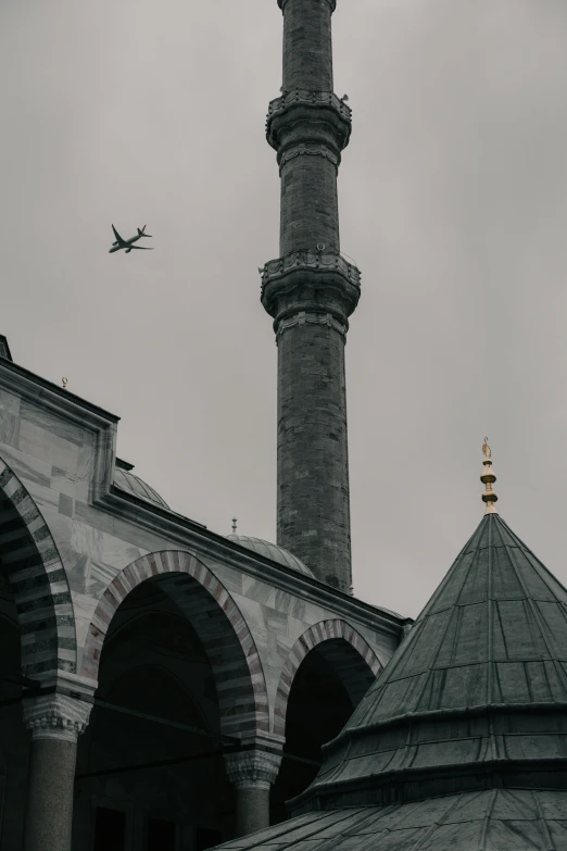 an airplane flying low over a city with some arches