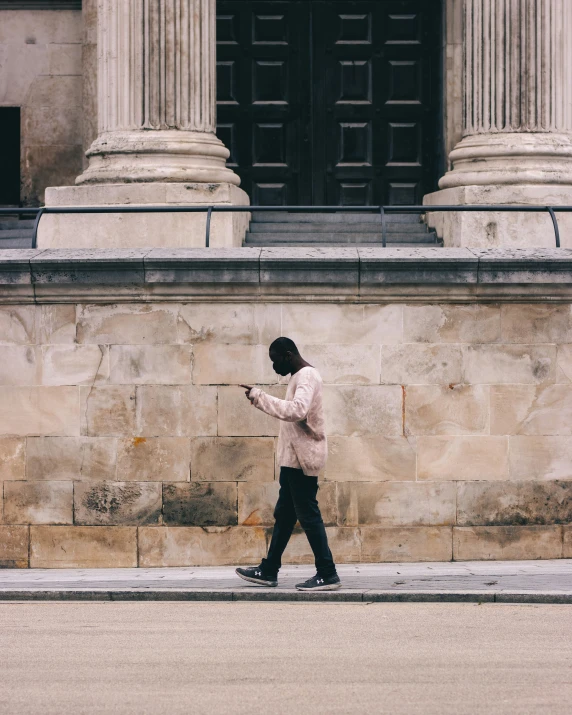 a person walking by a building and using a cell phone