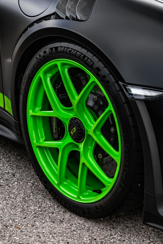 a green tire sits on the pavement of a car