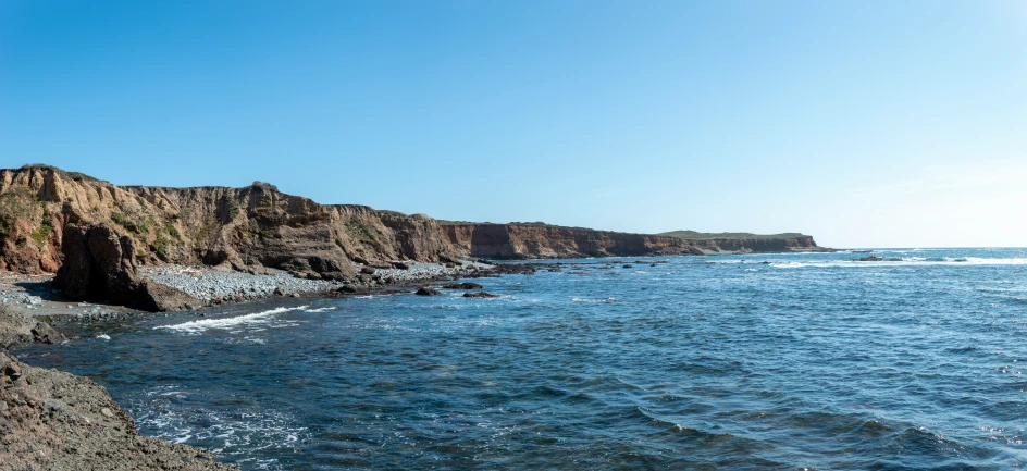 there are two mountains sitting in the distance on the coast