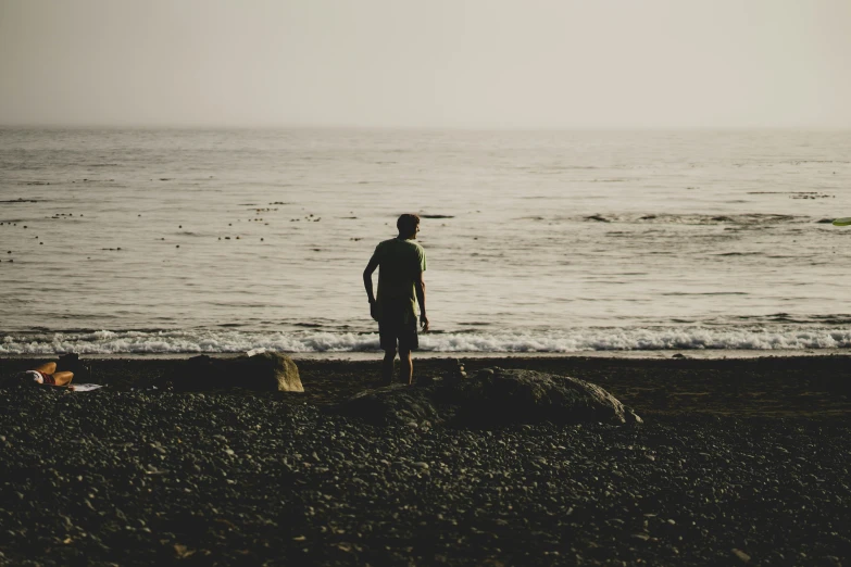 the person stands near the ocean watching soing