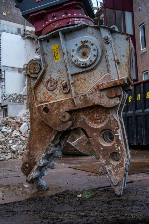 an older rusty piece of machinery is standing in the dirty yard