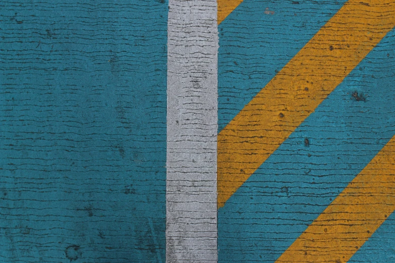 a close up of blue yellow and white paint on wood