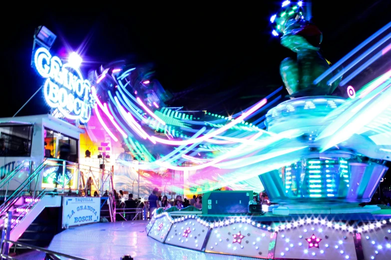 a carnival with lit up lights and rides