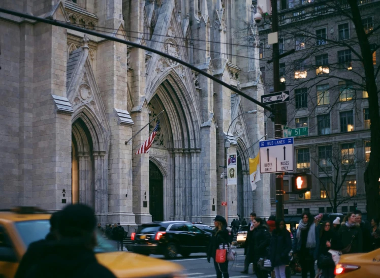 people walking down the street next to taxi cabs