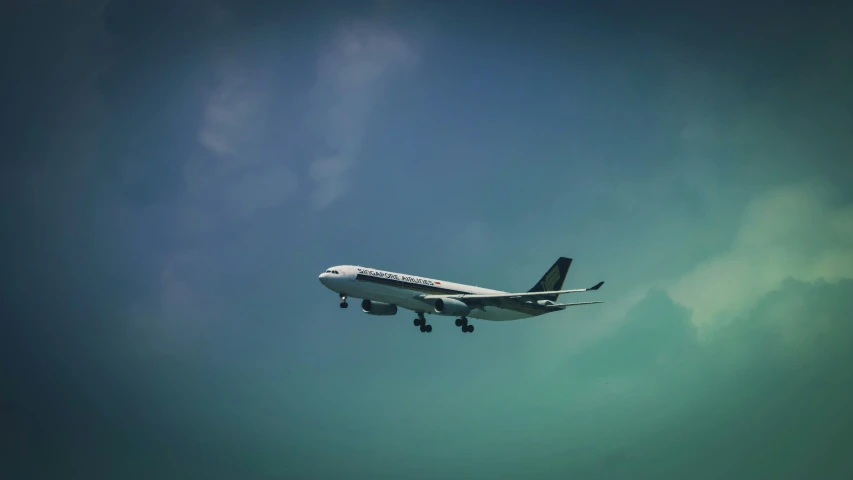 an airplane flying in the air on a cloudy day