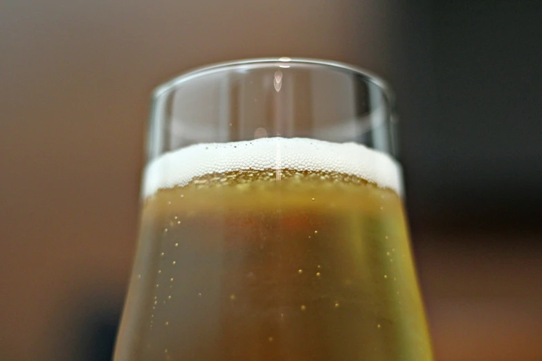 a glass of beer with some liquid inside