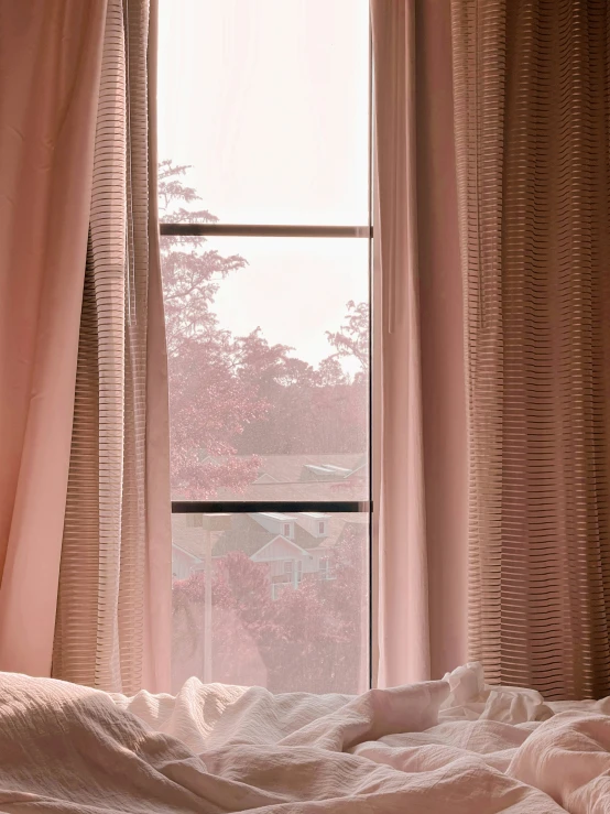 the bedroom with curtains, blankets and a window