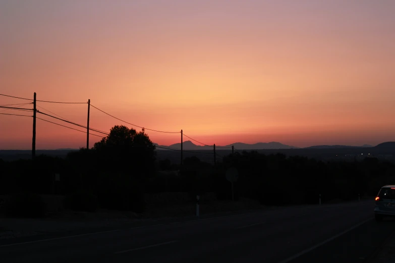 a car driving down the highway past power lines