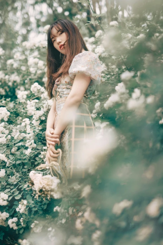 a young woman is posing in some flowers