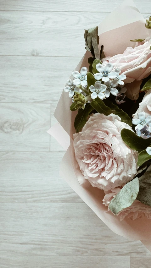 a bouquet of flowers on the wood with white and pink flowers