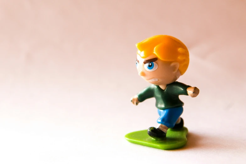 a toy figurine of a boy with blue eyes and hair