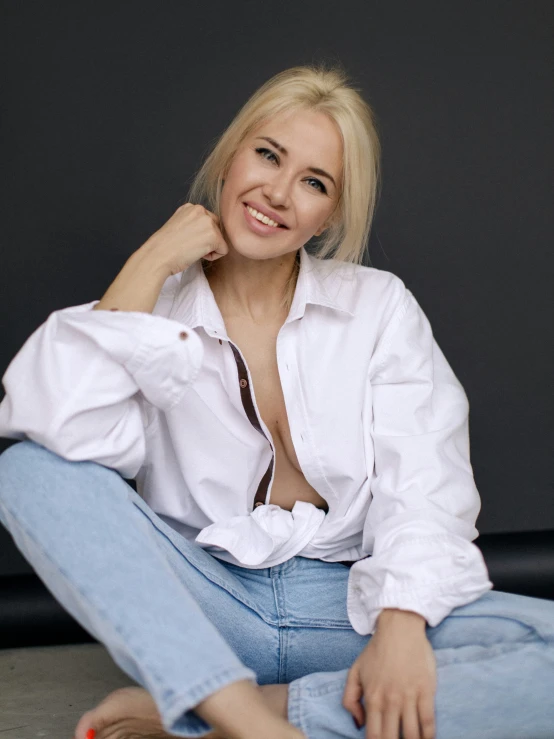 a woman sits on the floor posing for a picture