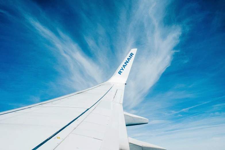 an airplane wing is in the middle of a blue sky