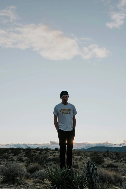 man standing on cactus in desert environment at dusk