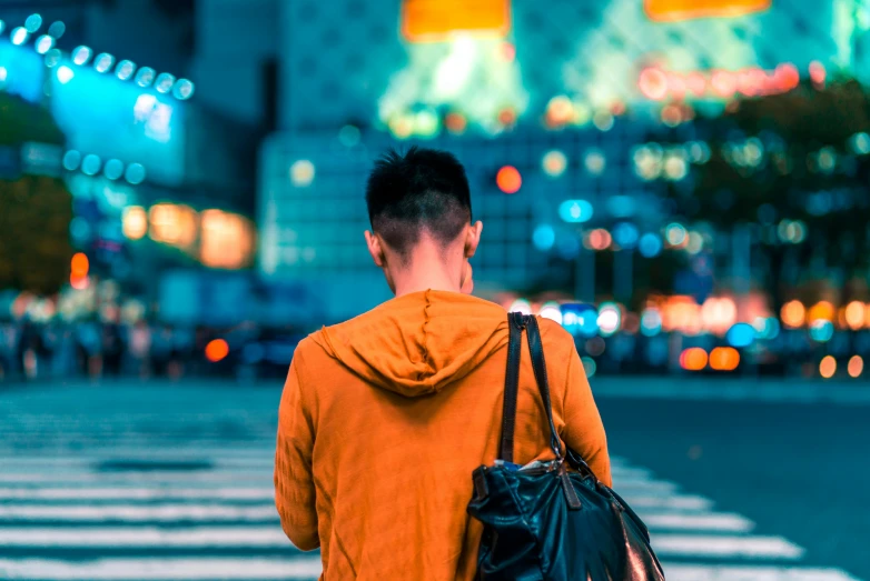 there is a man with an orange coat on crossing the street