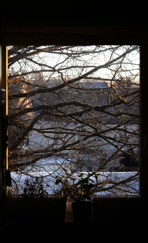 an open window with a view of a snowy town in the distance