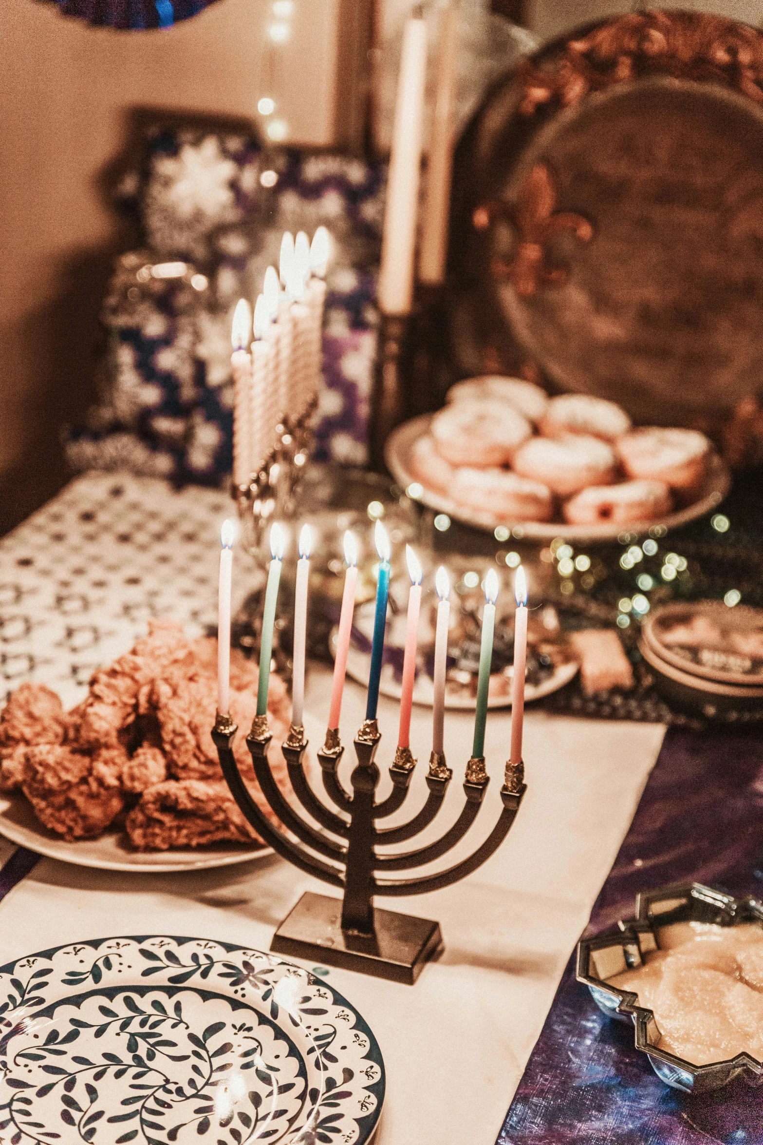 a dinner table with an menorah, cookies and donuts