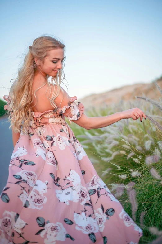 the  is walking down the path in a floral dress