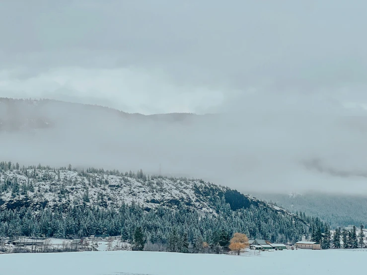 snow - covered mountains and buildings beneath a cloudy sky