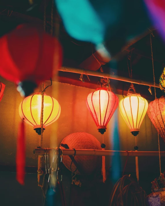 a bunch of lanterns with colored lighting in the background