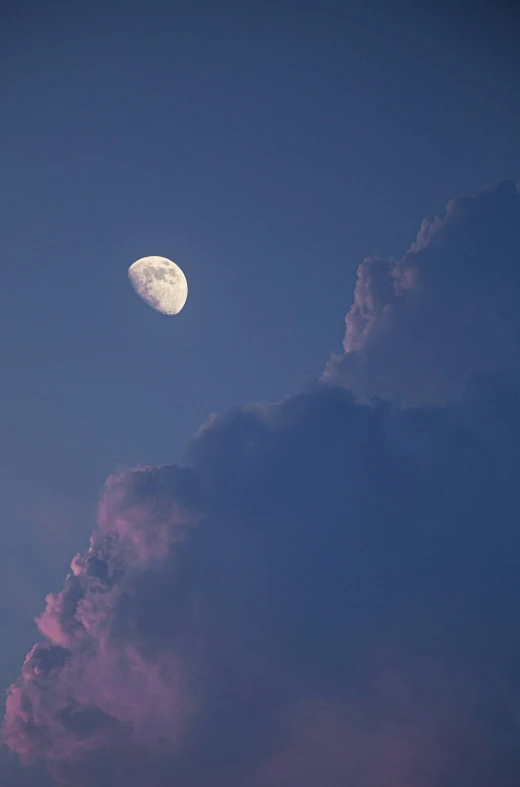 a full moon in the sky near some clouds