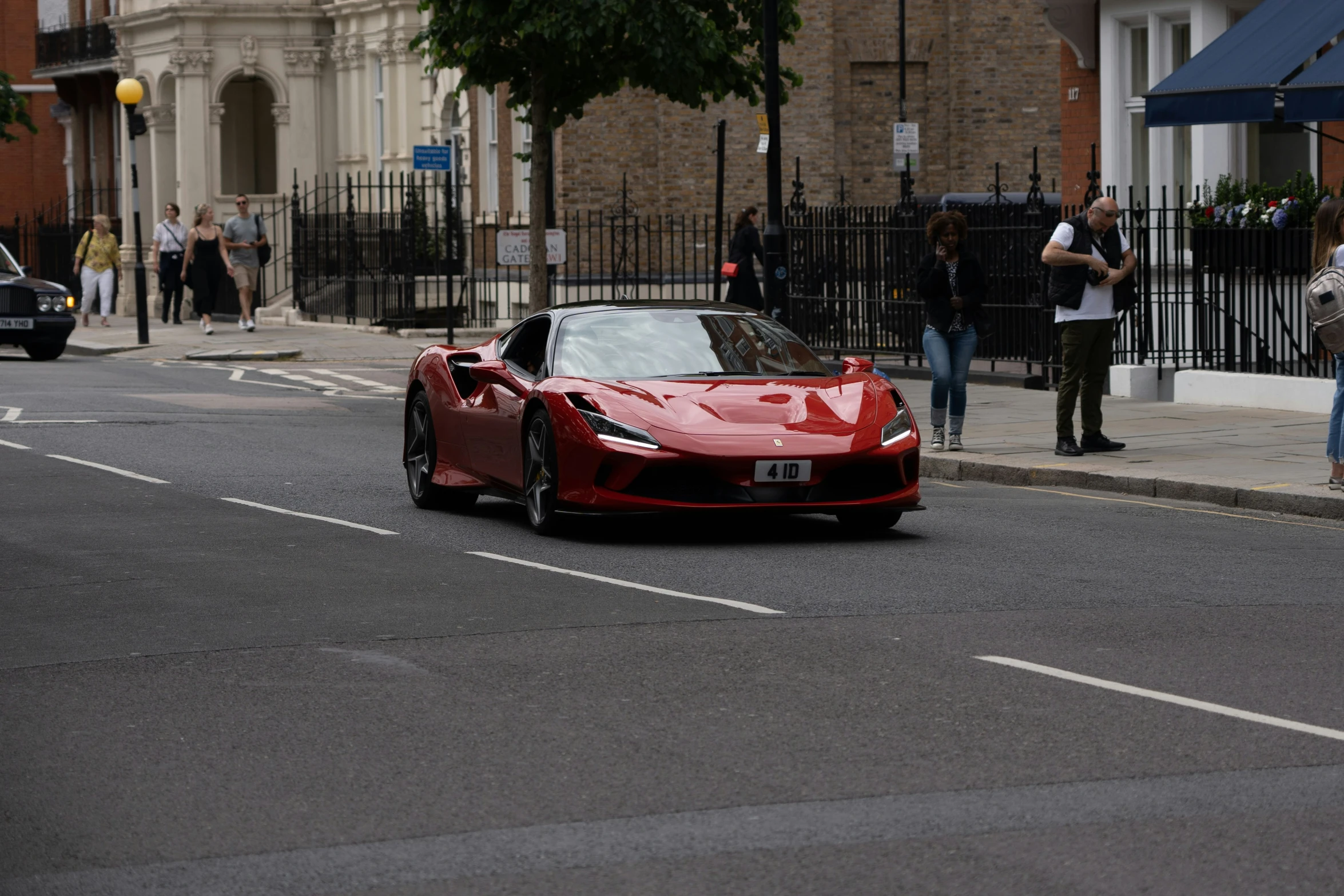 a red sports car is shown on the road in front of buildings