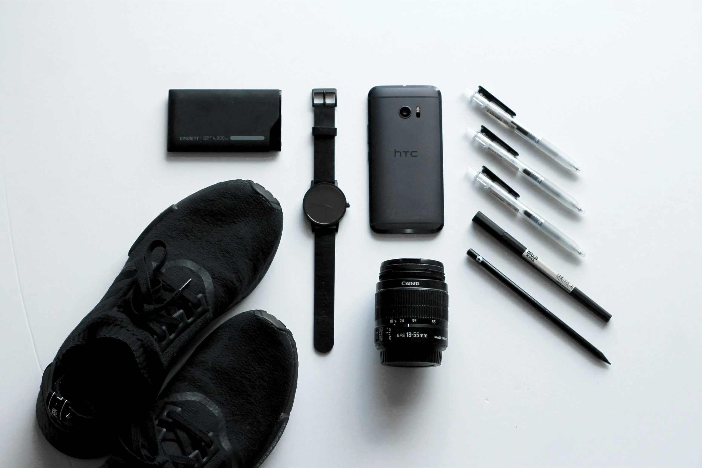 a man is sitting next to some pens and electronics