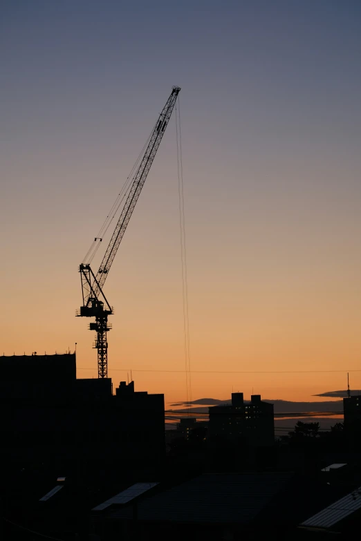 a building tower is silhouetted against the sunset