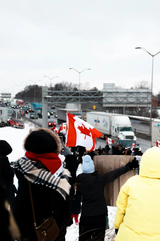 many people are standing in the snow holding flags