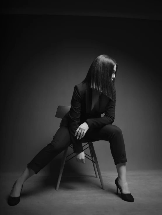 woman in dark sitting in chair and side view