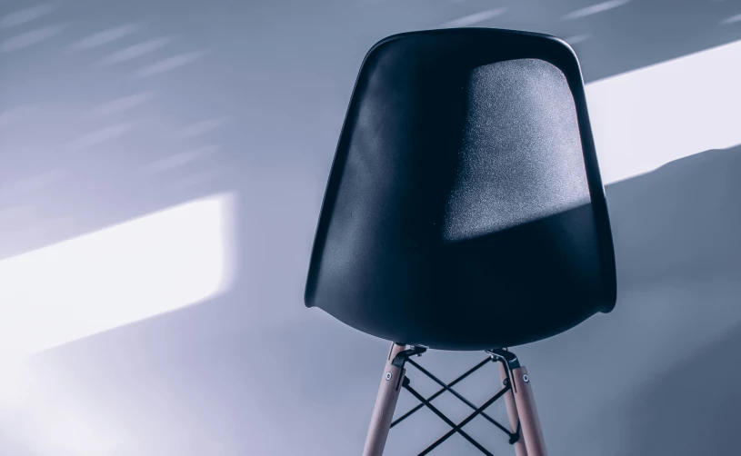 black and gold chair with wooden legs near window