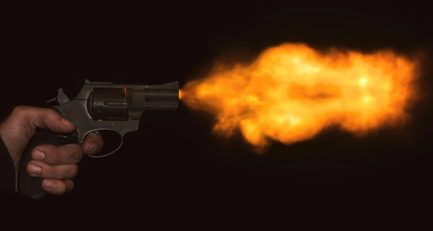 a burning gun pointing at a yellow flame behind it