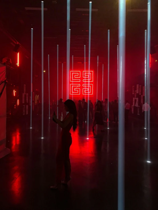 a person in a room with some poles and red lighting