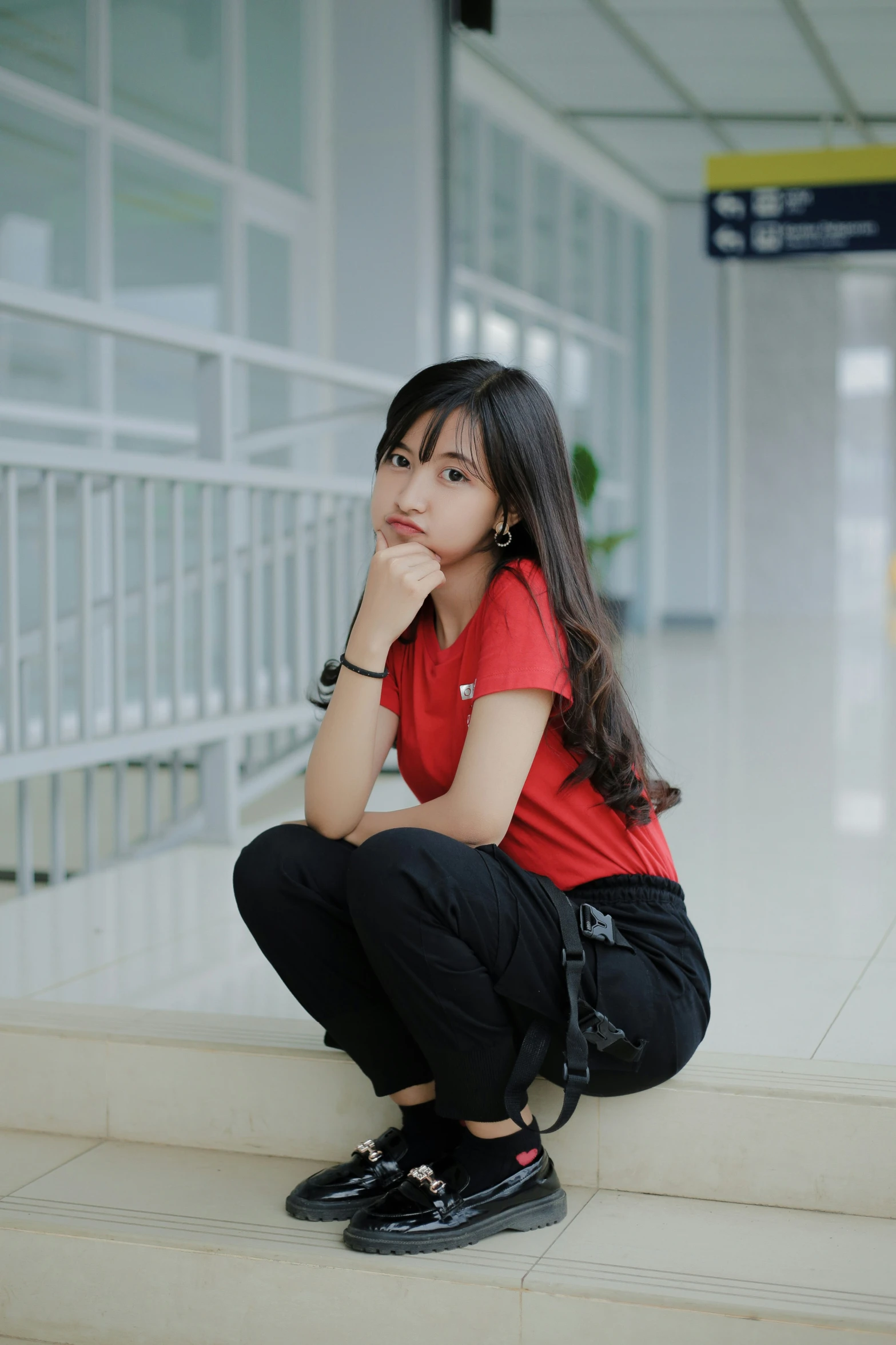 a woman sitting on the edge of some steps in a building