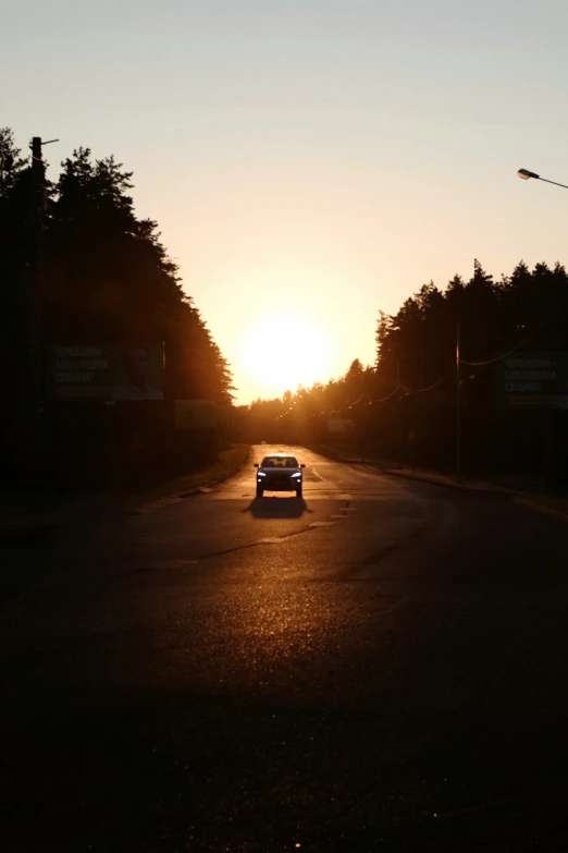 a car driving down the road at sunset