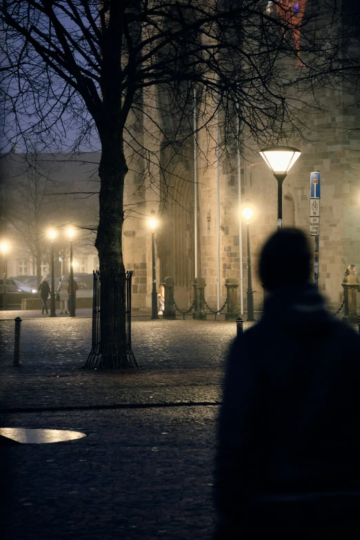 a person walking at night in front of an urban building