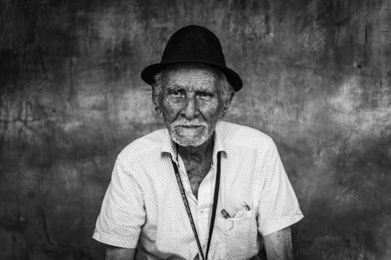a black and white po of an old man with a hat and chain