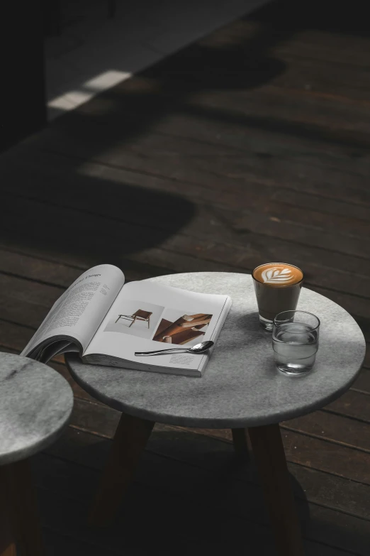 a book open on a table with coffee and drinks