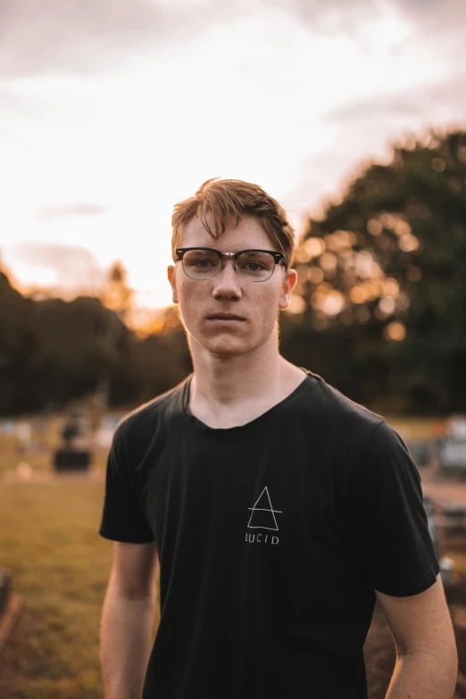 a young man is standing by himself in a field