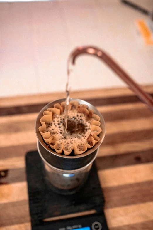 a drink being poured into a shaker filled with sugar and cinnamons